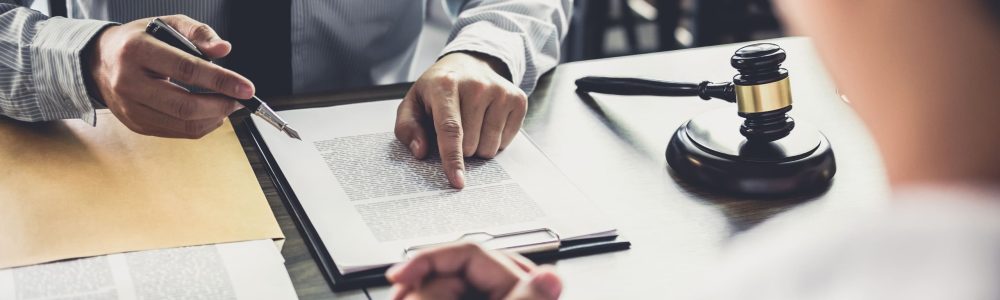 midsection-judge-pointing-document-while-worried-client-sitting-table